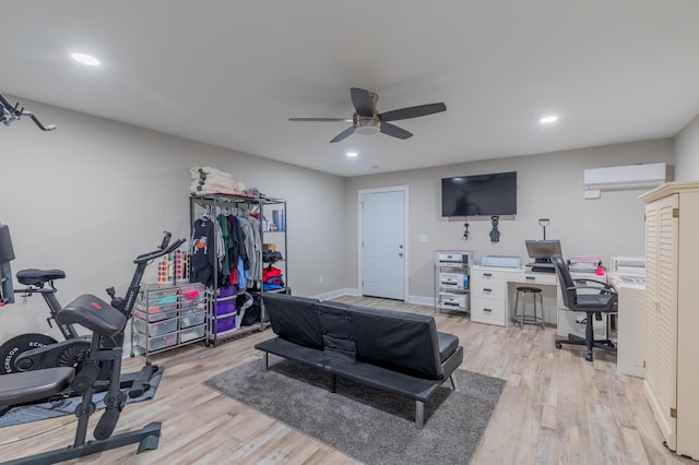 exercise area with ceiling fan, light hardwood / wood-style floors, and a wall unit AC