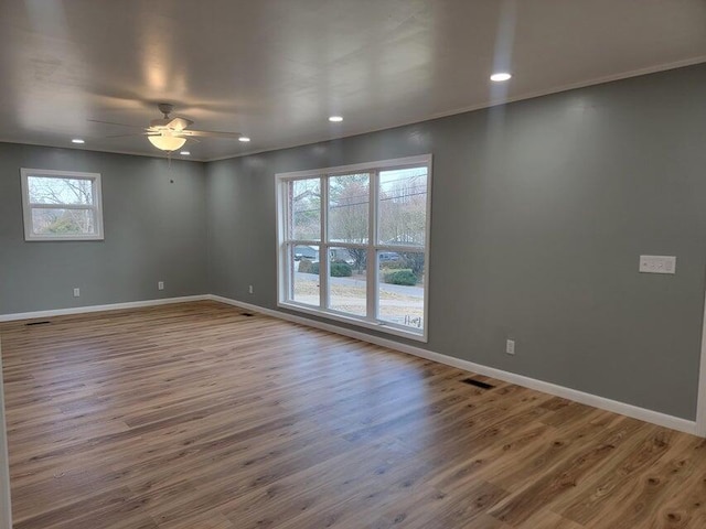 spare room with wood finished floors, ceiling fan, baseboards, and recessed lighting