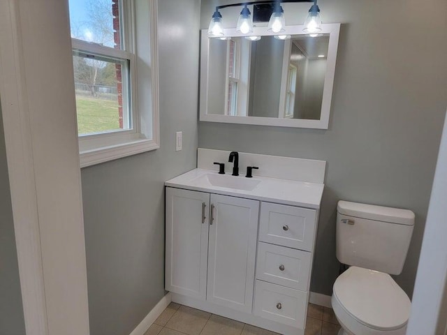 bathroom featuring tile patterned floors, vanity, baseboards, and toilet