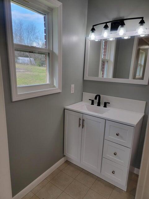 bathroom featuring baseboards, tile patterned flooring, and vanity