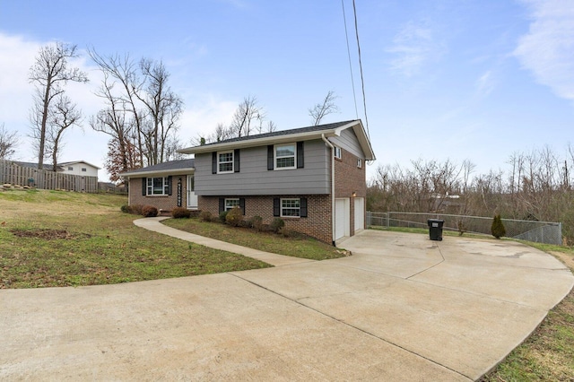 tri-level home featuring a garage and a front yard