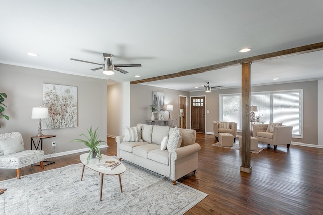 living room featuring dark hardwood / wood-style flooring, ceiling fan, ornamental molding, and beamed ceiling