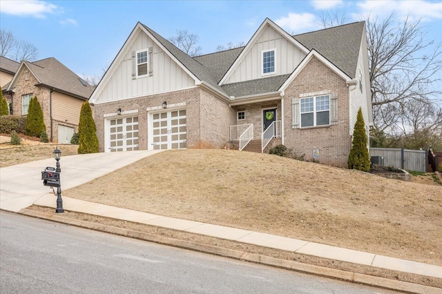 view of front of house featuring brick siding, a shingled roof, fence, driveway, and board and batten siding