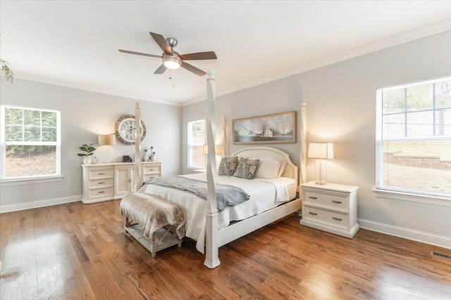 bedroom featuring ornamental molding, multiple windows, and wood finished floors