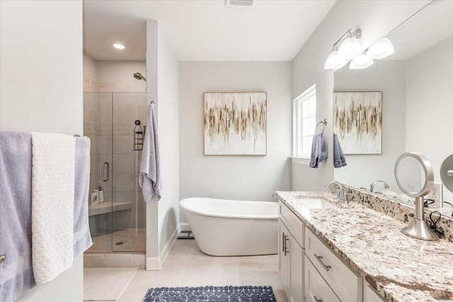 full bathroom with tile patterned flooring, visible vents, vanity, a soaking tub, and a stall shower