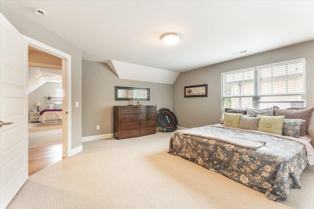 carpeted bedroom with lofted ceiling, visible vents, and baseboards