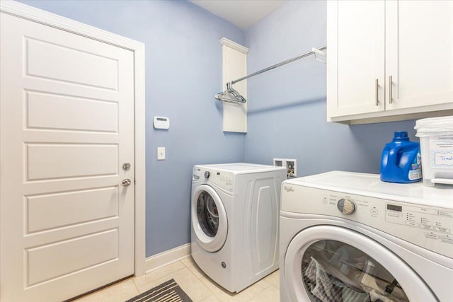 laundry room featuring cabinet space, light tile patterned floors, baseboards, and washer and clothes dryer