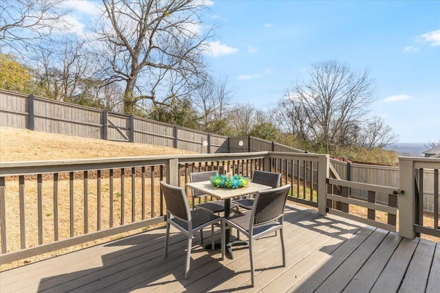 deck with outdoor dining area and a fenced backyard