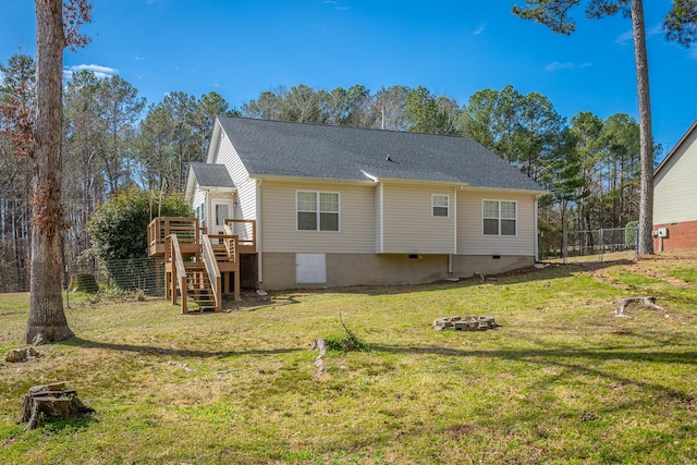 back of property featuring a lawn, crawl space, fence, a wooden deck, and stairs