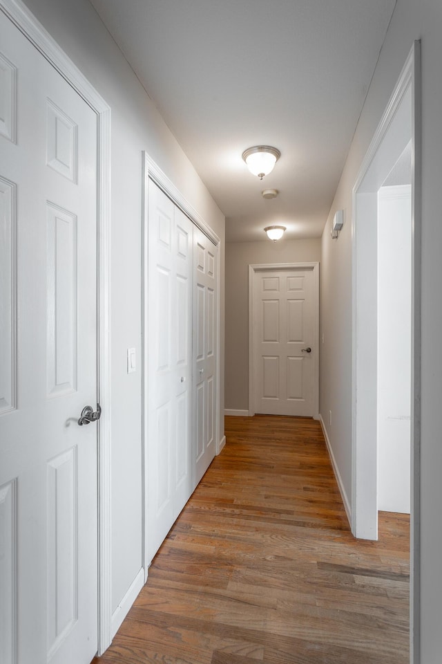 hall featuring baseboards and wood finished floors