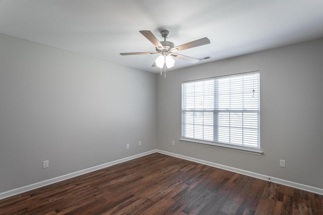 empty room with ceiling fan, visible vents, baseboards, and dark wood finished floors