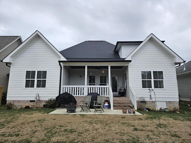 back of house featuring a patio, a yard, a fire pit, and a porch