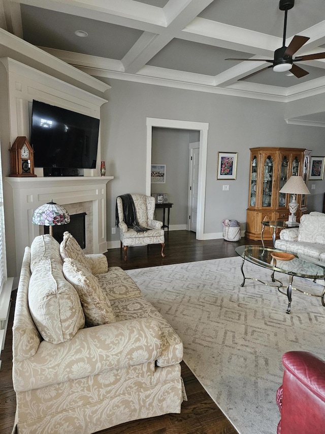 living room featuring beam ceiling, dark wood-type flooring, ceiling fan, coffered ceiling, and a fireplace