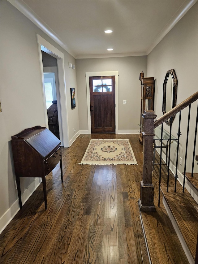 foyer entrance featuring ornamental molding and dark hardwood / wood-style floors