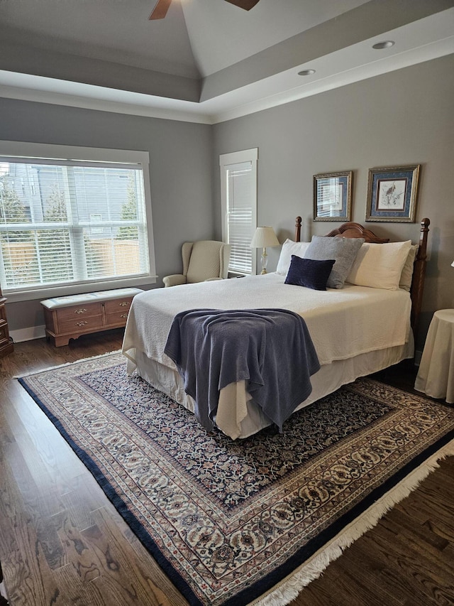 bedroom featuring a tray ceiling, vaulted ceiling, ceiling fan, and wood-type flooring