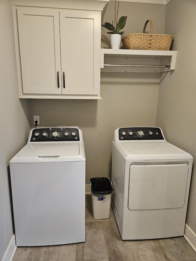 washroom with cabinets and washer and clothes dryer