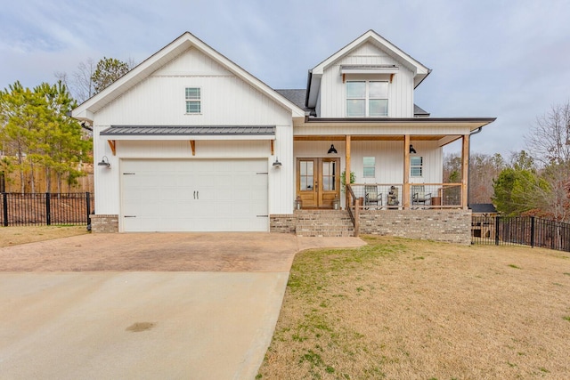 view of front of property with a garage, a front lawn, french doors, and a porch