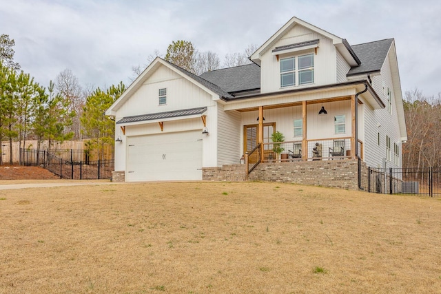 view of front of property featuring a garage, covered porch, and a front lawn