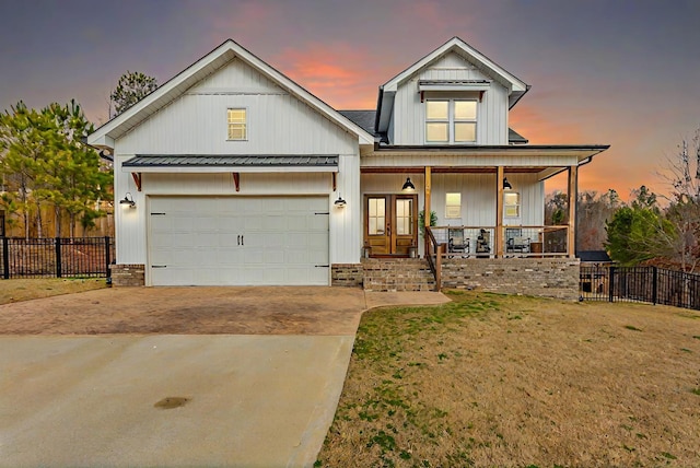 view of front of home featuring a porch, a garage, and a yard