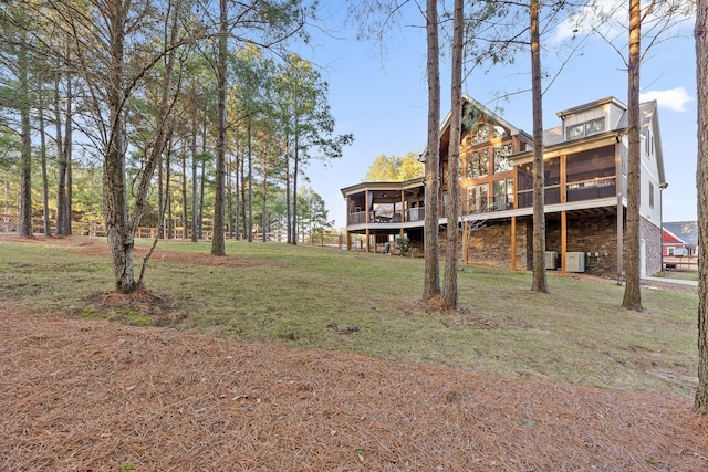 rear view of property featuring a yard and a sunroom