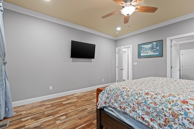 bedroom featuring crown molding, wood-type flooring, and ceiling fan