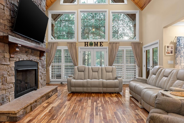 living room featuring hardwood / wood-style floors, a fireplace, and high vaulted ceiling