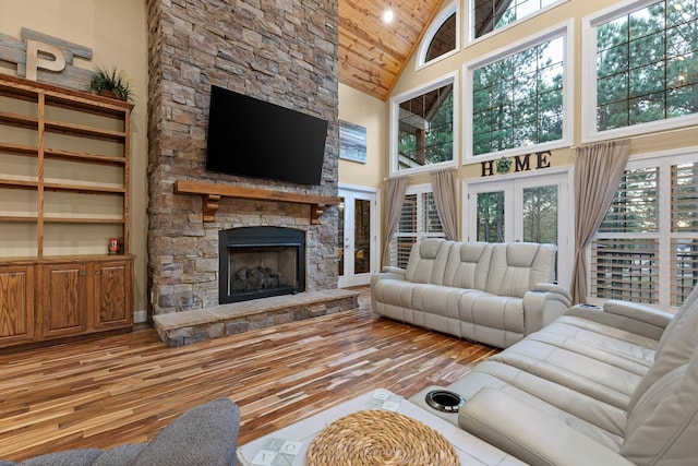 living room featuring french doors, high vaulted ceiling, wooden ceiling, a fireplace, and hardwood / wood-style floors