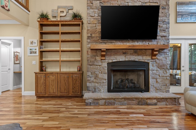 unfurnished living room with a stone fireplace and light hardwood / wood-style floors