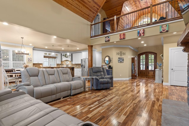 living room with high vaulted ceiling, light wood-type flooring, wooden ceiling, an inviting chandelier, and french doors