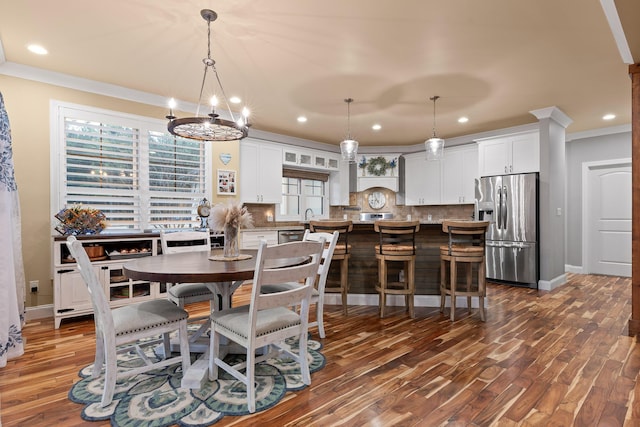 dining room featuring crown molding, dark wood-type flooring, and sink