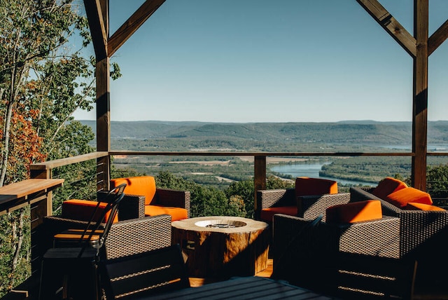 deck with an outdoor fire pit and a water and mountain view