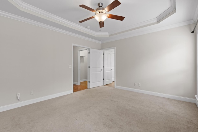 unfurnished room featuring crown molding, light colored carpet, and a tray ceiling