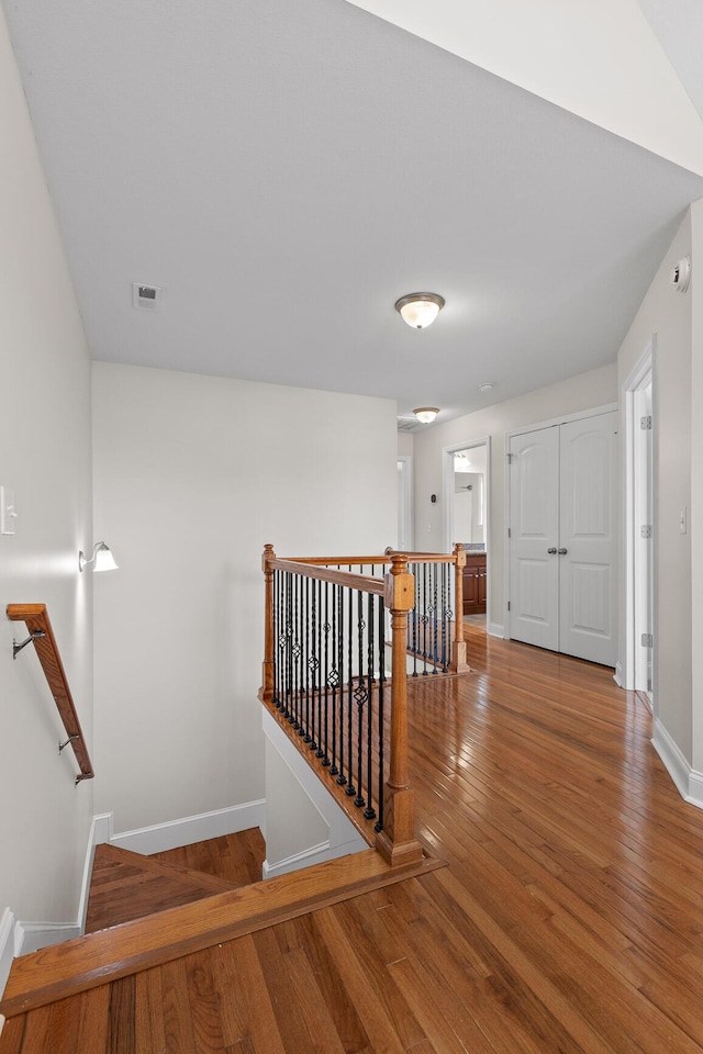 staircase with hardwood / wood-style flooring