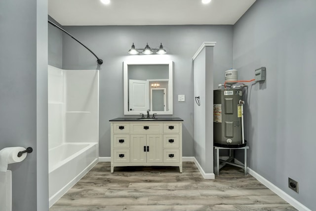 bathroom featuring shower / bathtub combination, vanity, electric water heater, and hardwood / wood-style floors