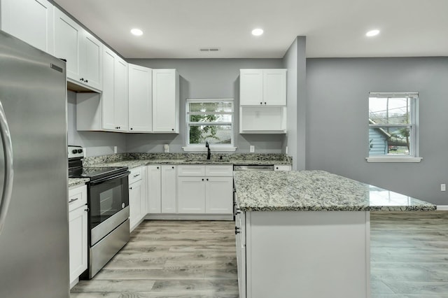 kitchen with sink, stainless steel appliances, white cabinets, and a kitchen island