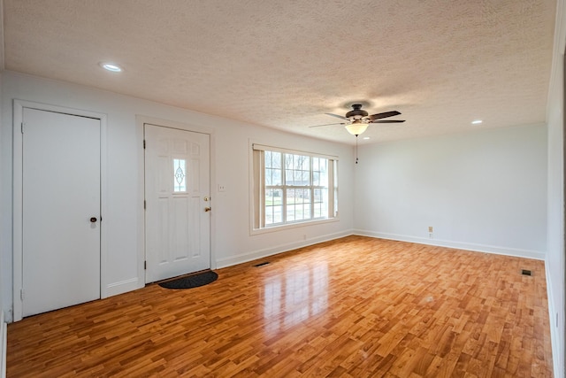 foyer with ceiling fan, light hardwood / wood-style floors, and a textured ceiling