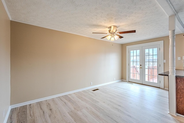 unfurnished room with a textured ceiling, french doors, ceiling fan, and light wood-type flooring