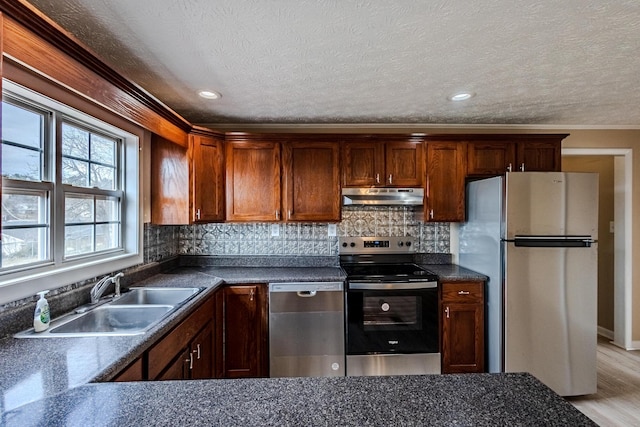 kitchen featuring appliances with stainless steel finishes, sink, a textured ceiling, and decorative backsplash