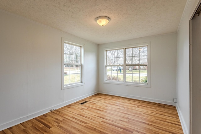 unfurnished room with ornamental molding, light hardwood / wood-style floors, and a textured ceiling