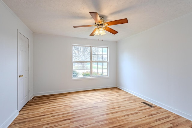 spare room with ornamental molding, ceiling fan, a textured ceiling, and light hardwood / wood-style floors