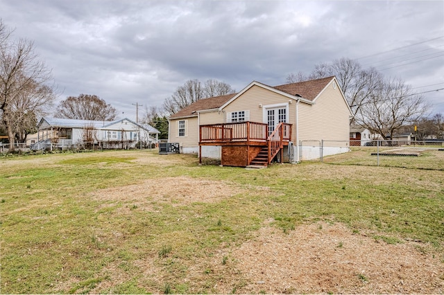 rear view of house with a wooden deck, central AC, and a lawn