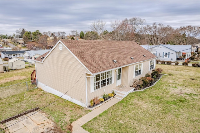 rear view of property featuring a yard and a shed