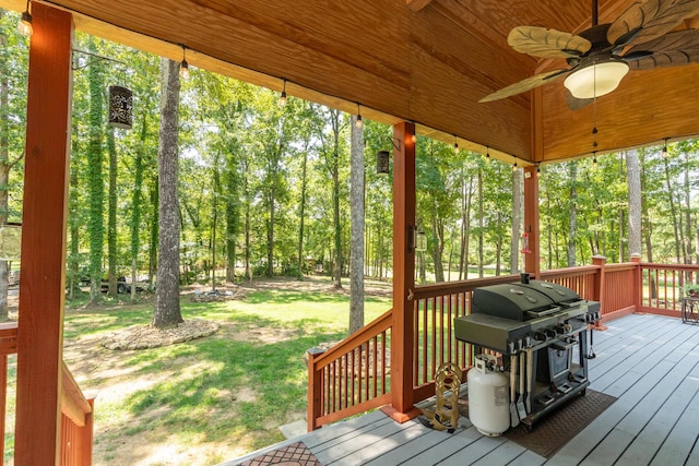 wooden deck featuring a grill, a yard, and ceiling fan