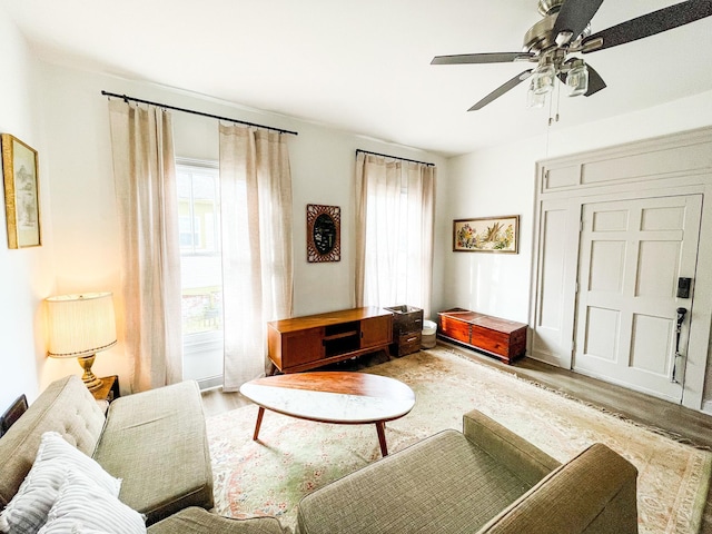 living room with wood finished floors and a ceiling fan