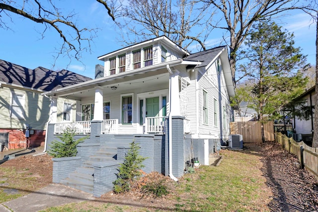 view of front of home featuring covered porch, stairway, cooling unit, and fence