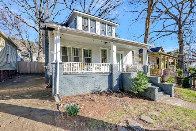 bungalow-style house featuring covered porch and fence