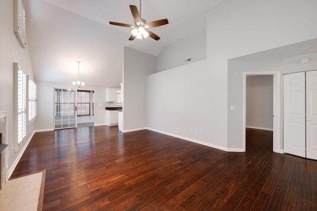 unfurnished living room featuring baseboards, wood finished floors, and ceiling fan with notable chandelier