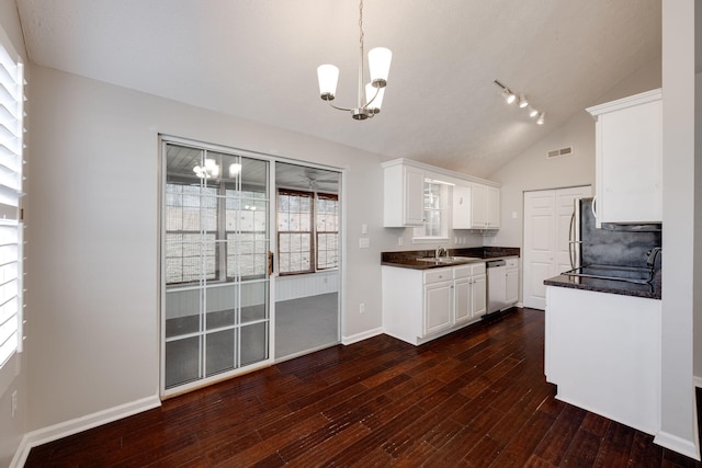 kitchen featuring dishwashing machine, dark countertops, a sink, and visible vents