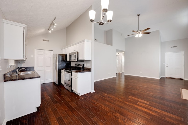 kitchen with visible vents, appliances with stainless steel finishes, open floor plan, white cabinetry, and a sink