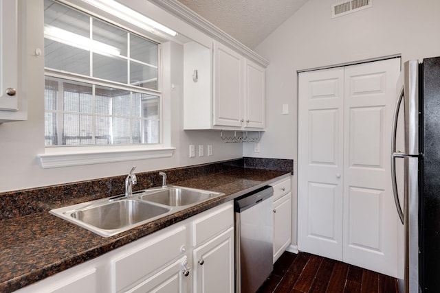 kitchen with visible vents, white cabinets, appliances with stainless steel finishes, dark wood-style flooring, and vaulted ceiling